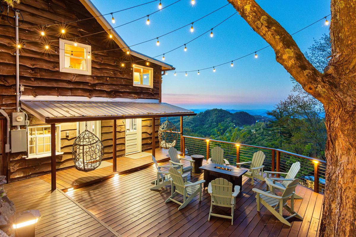 The Grand Cabin deck at twilight with string lights and mountain views