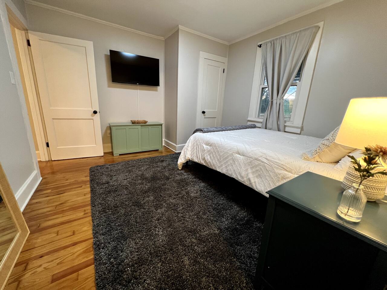 Primary bedroom with queen bed and wall-mounted TV