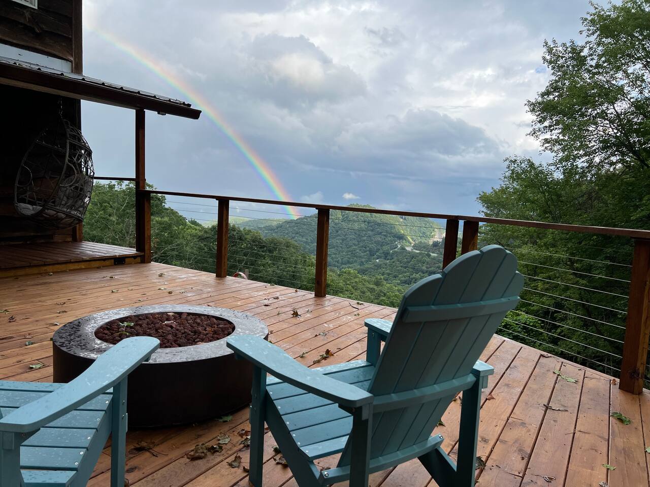 Gas fire pit and Adirondack chairs on the deck with a rainbow over the gorge
