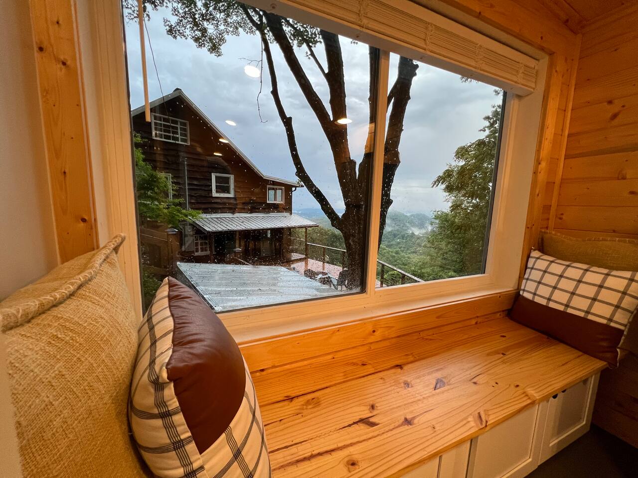 The window nook — a built-in bench seat under a picture window with cushions