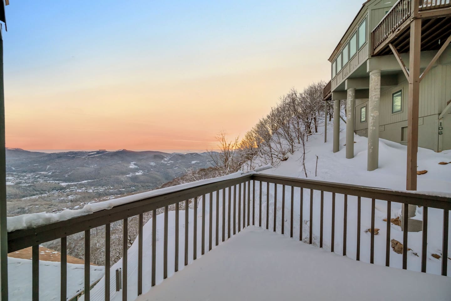 Snow-covered deck beside the chalet at sunset