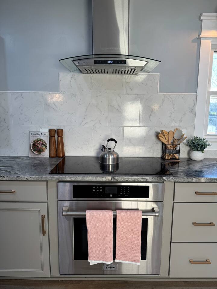 Main House cooktop, wall oven and marble tile backsplash